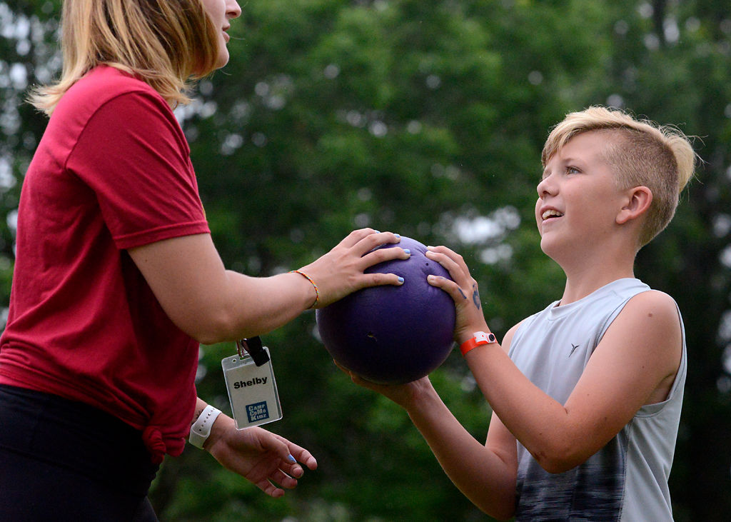 Ben Hansmen, 11, and camp counselor Shelby Johnson pass off the ball